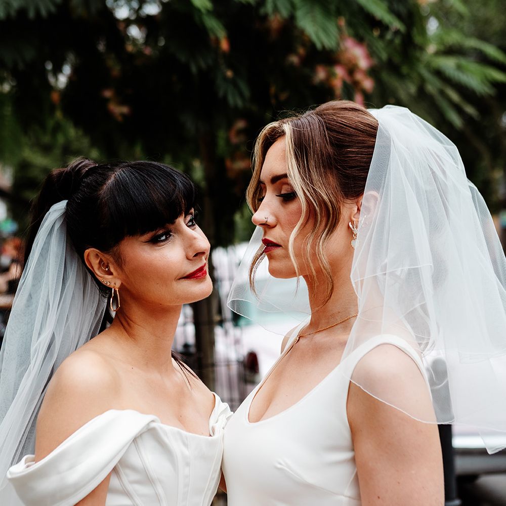 bride-wears-short-wedding-veil-gazing-at-bride-in-off-the-shoulder-dress
