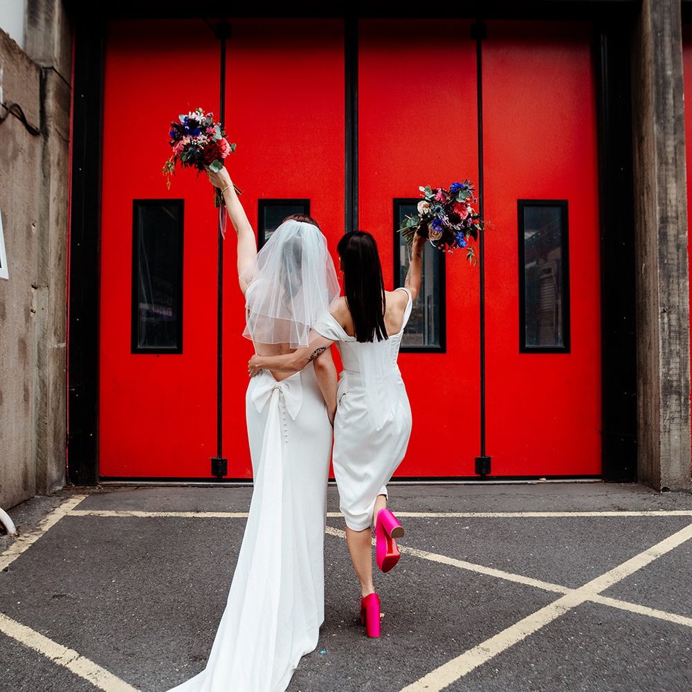 brides-pose-tgether-in-front-of-love-sign