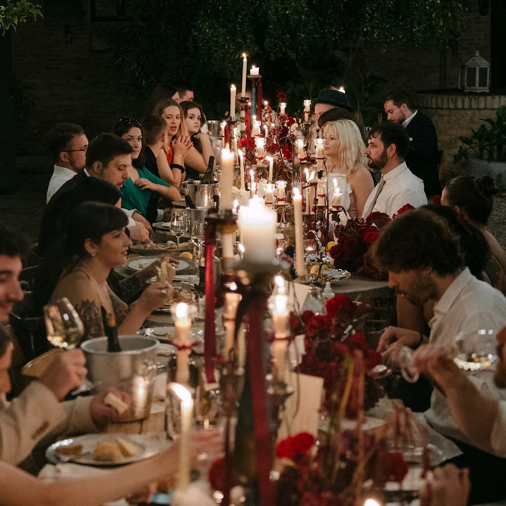 wedding-guests-seated-at-wedding-breakfast-lit-by-candles