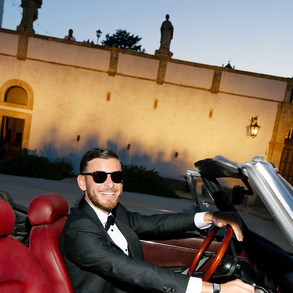 groom-driving-luxe-sports-car-with-red-leather-interior.