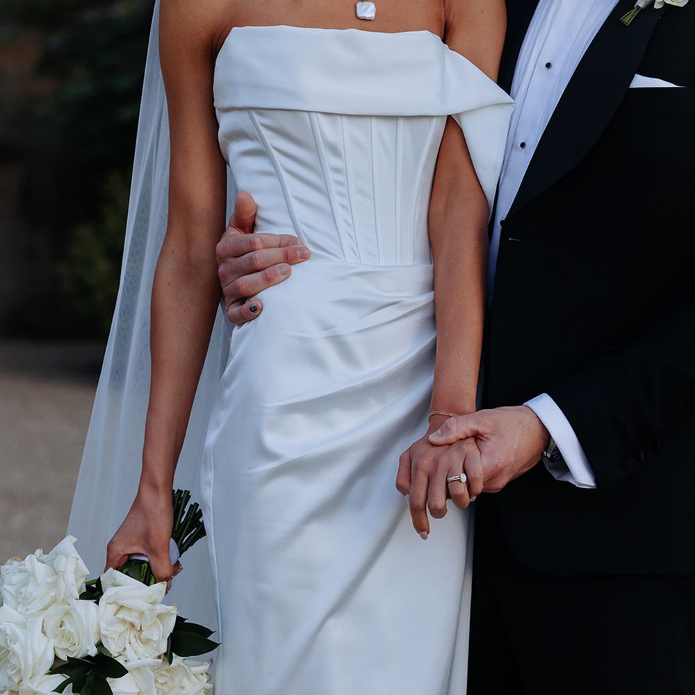 bride-in-on-shoulder-corset-wedding-dress-with-white-rose-bouquet