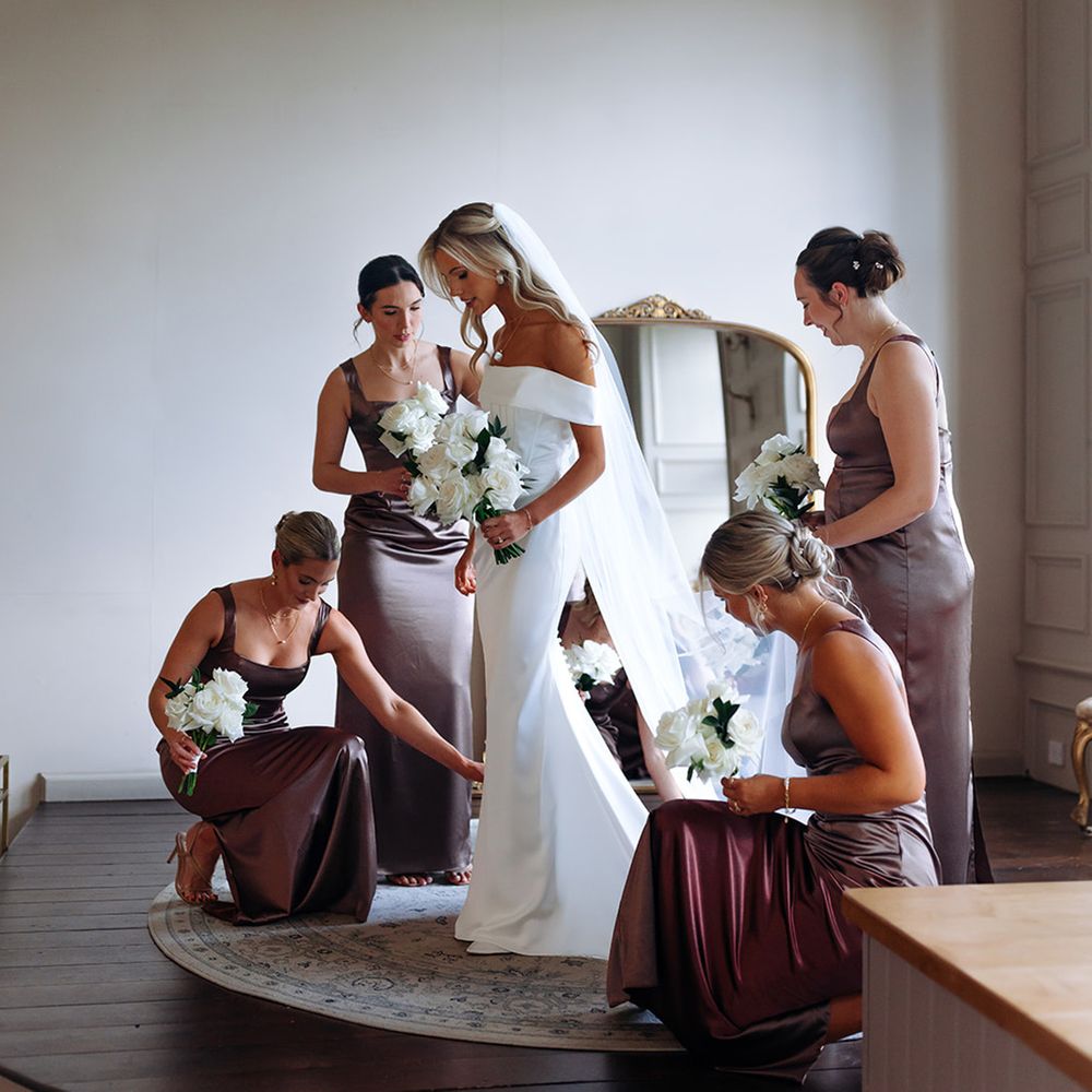 bridesmaids-in-plum-satin-dresses-helping-bride-get-ready