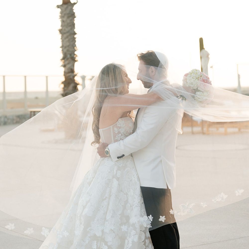 bride-wearing-flower-embroidered-veil-posing-with-groom