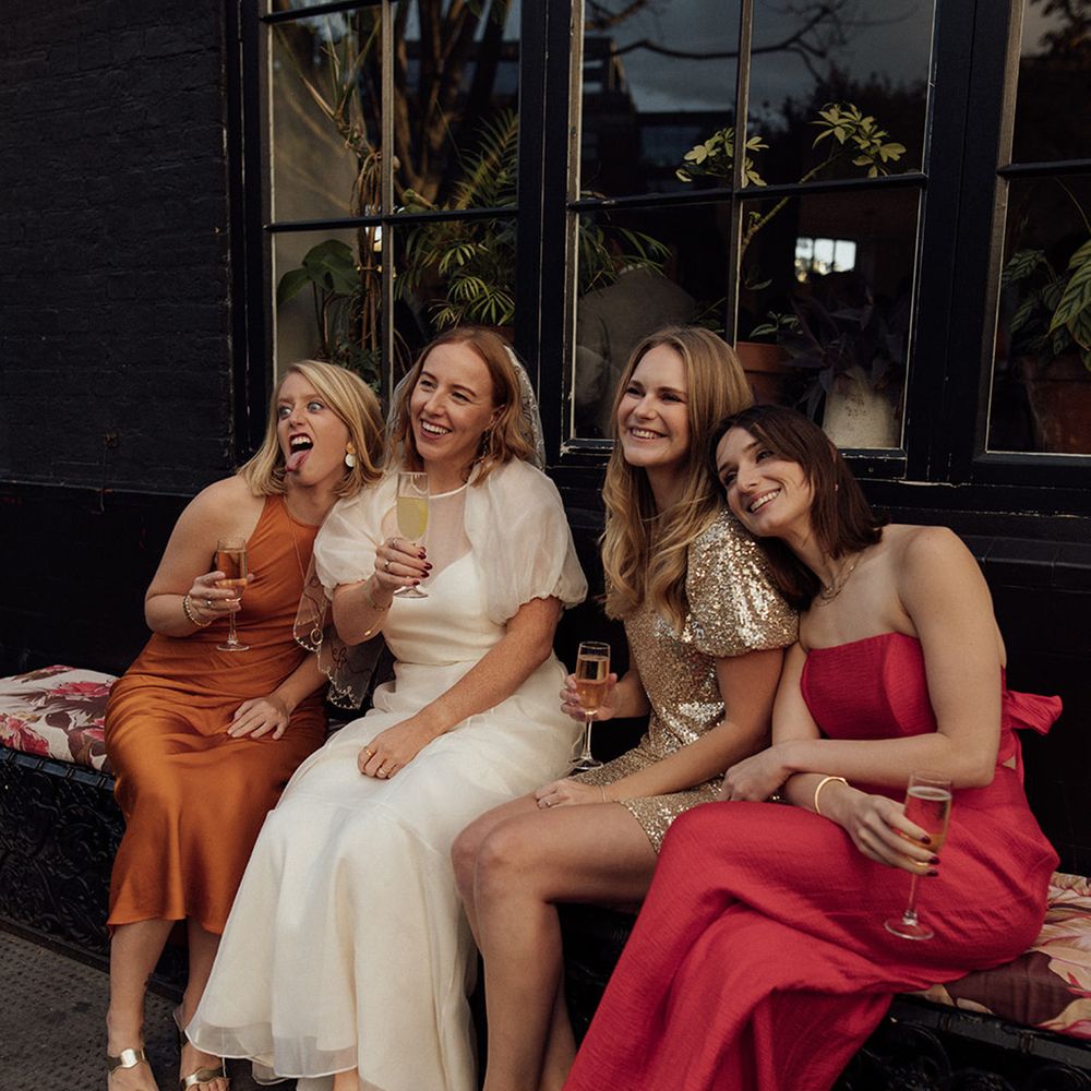 bride-sits-posing-with-wedding-guests