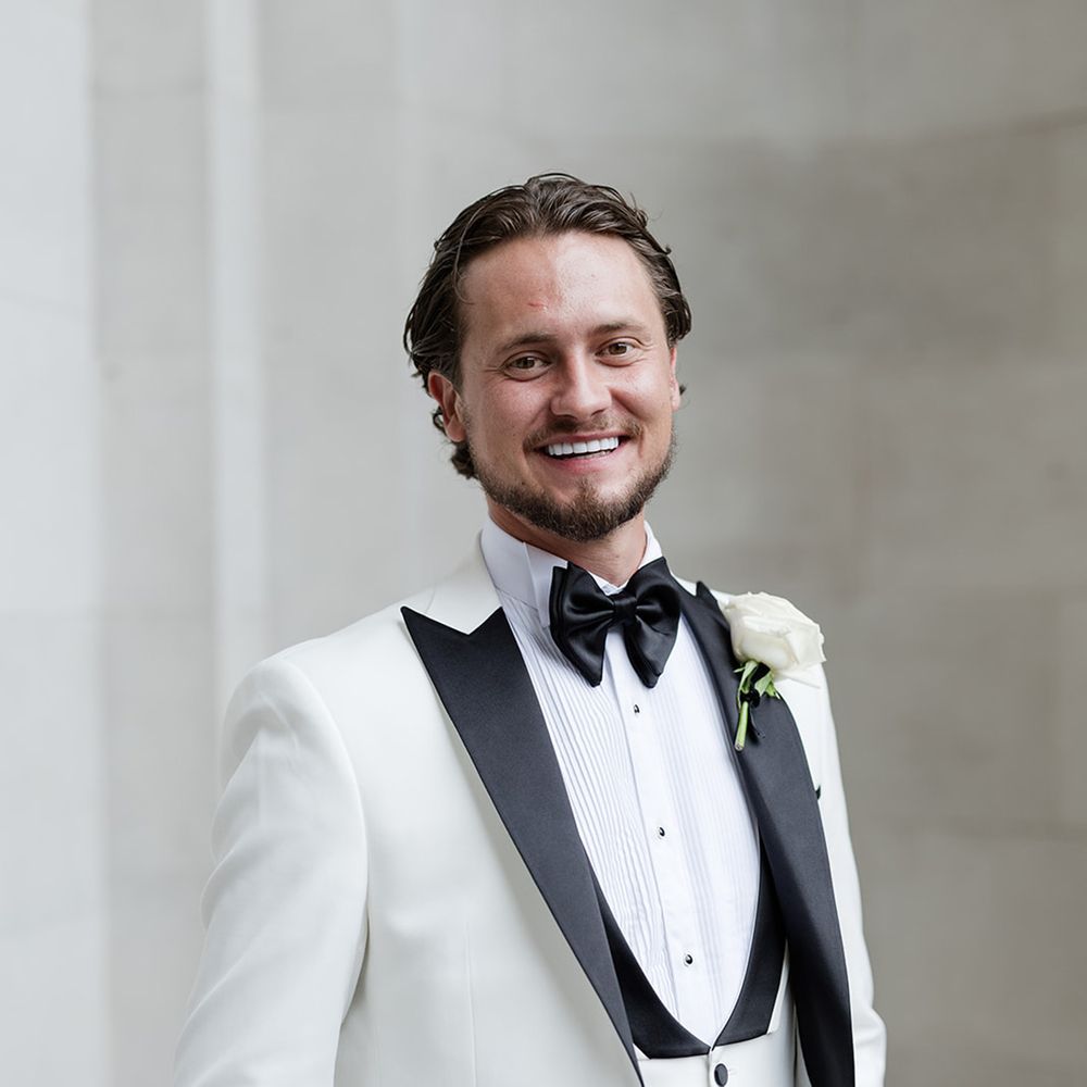 groom-in-black-and-white-wedding-tuxedo-with-rose-buttonhole