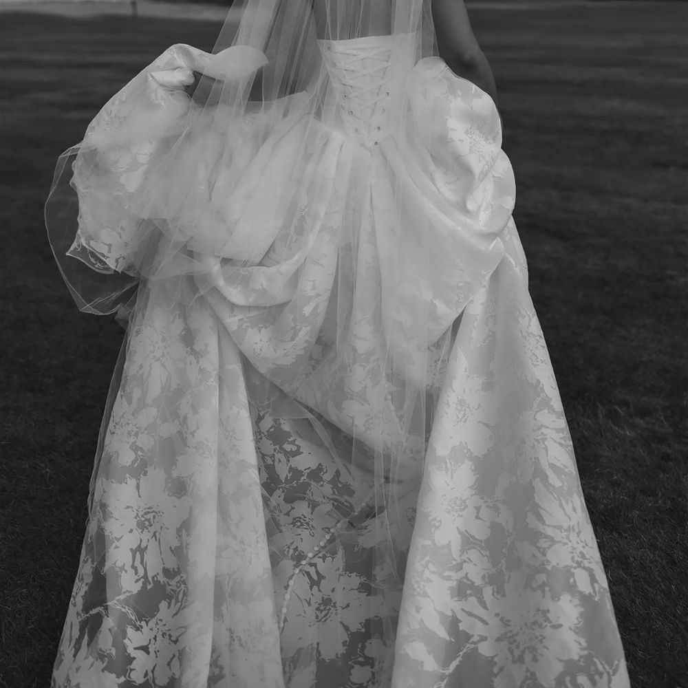 Bride wearing floral corset wedding dress with long train