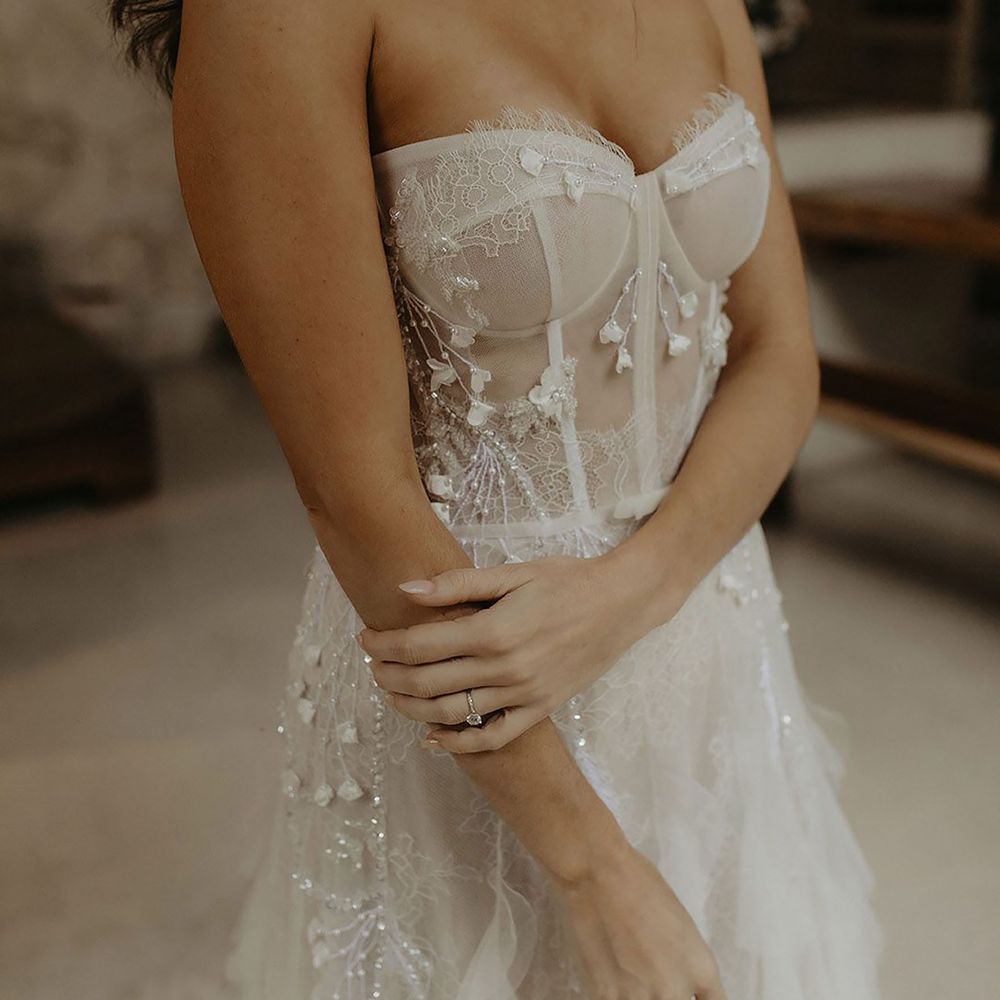 Bride wearing floral embellished sheer mesh corset wedding dress