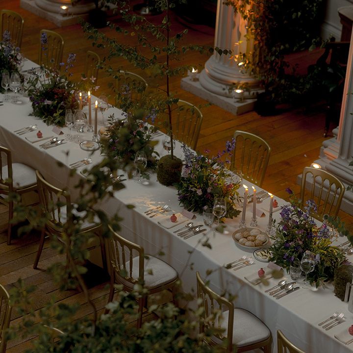Banquet style tables with purple wedding flowers 