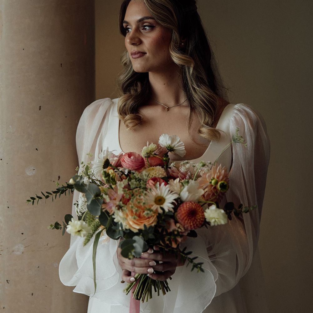 bride-in-puff-sleeve-wedding-dress-with-pink-bouquet