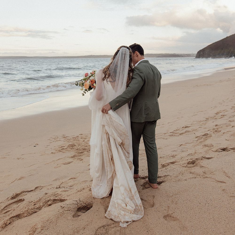 couple-walks-on-beach-for-coastal-wedding
