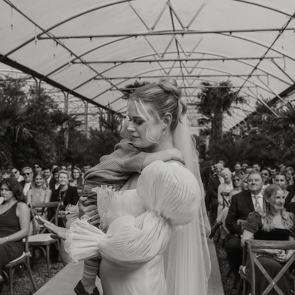 bride-reading-wedding-vows-carrying-baby