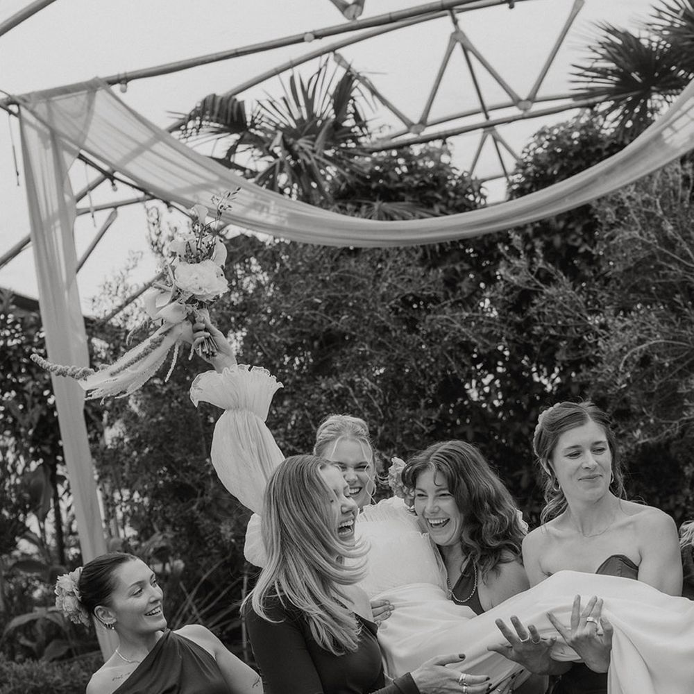 bridesmaids-lift-bride-at-botanical-wedding