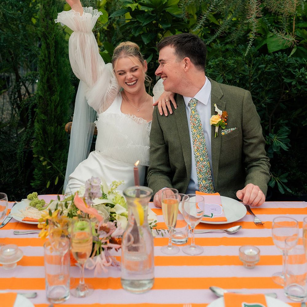 couple-seated-at-their-wedding-breakfast-with-striped-table