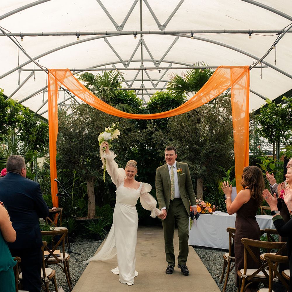couple-walks-back-down-the-aisle-at-botanical-wedding-venue
