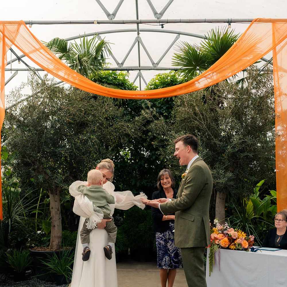 official-wedding-ceremony-with-bride-holding-hands-with-groom-and-holding-baby