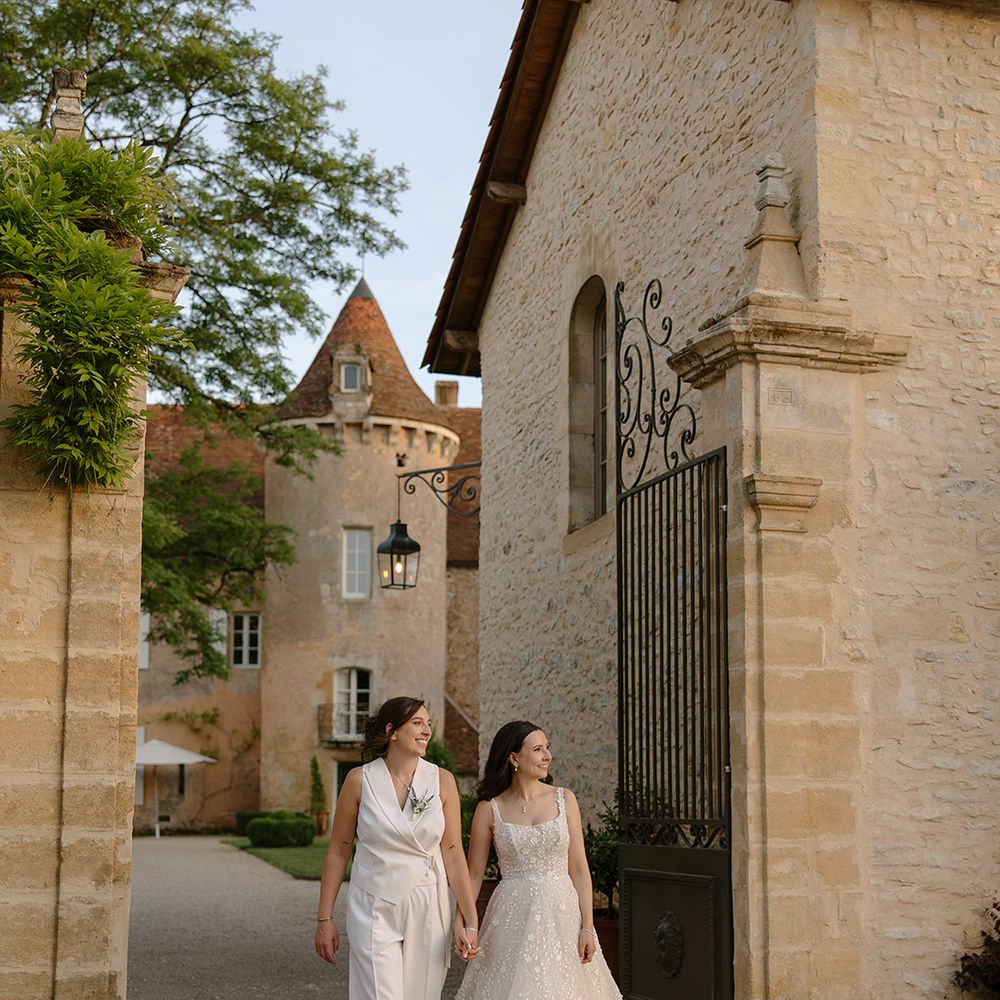Brides walking hand in hand at outdoor wedding 