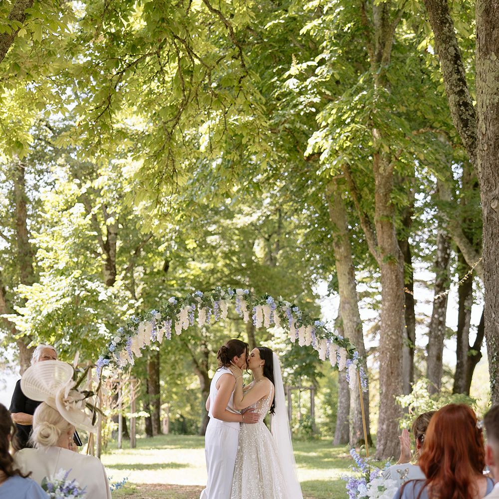 First kiss for two brides at outdoor wedding 