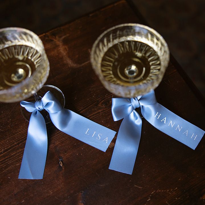 Personalised blue ribbons decorating coupe glasses