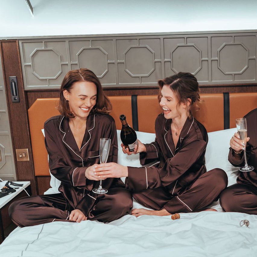 Bridesmaids in brown PJs getting ready together 