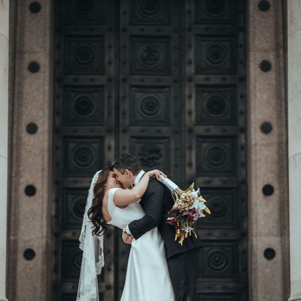 Couple kisses in front of doorway 