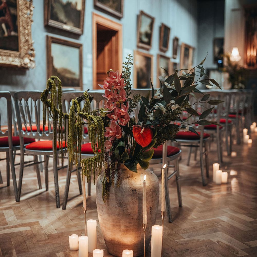 Metallic vases with vibrant flowers for aisle decor
