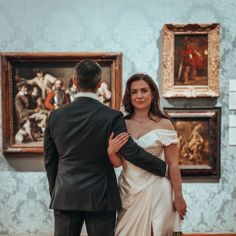 Museum wedding with groom embracing bride in Vivienne Westwood wedding dress
