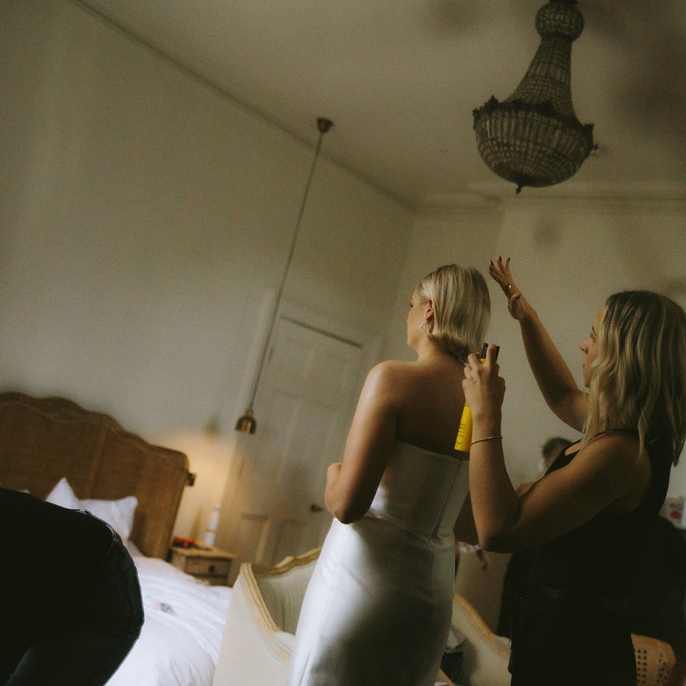 Wedding hairstylist styling bride’s hair getting ready