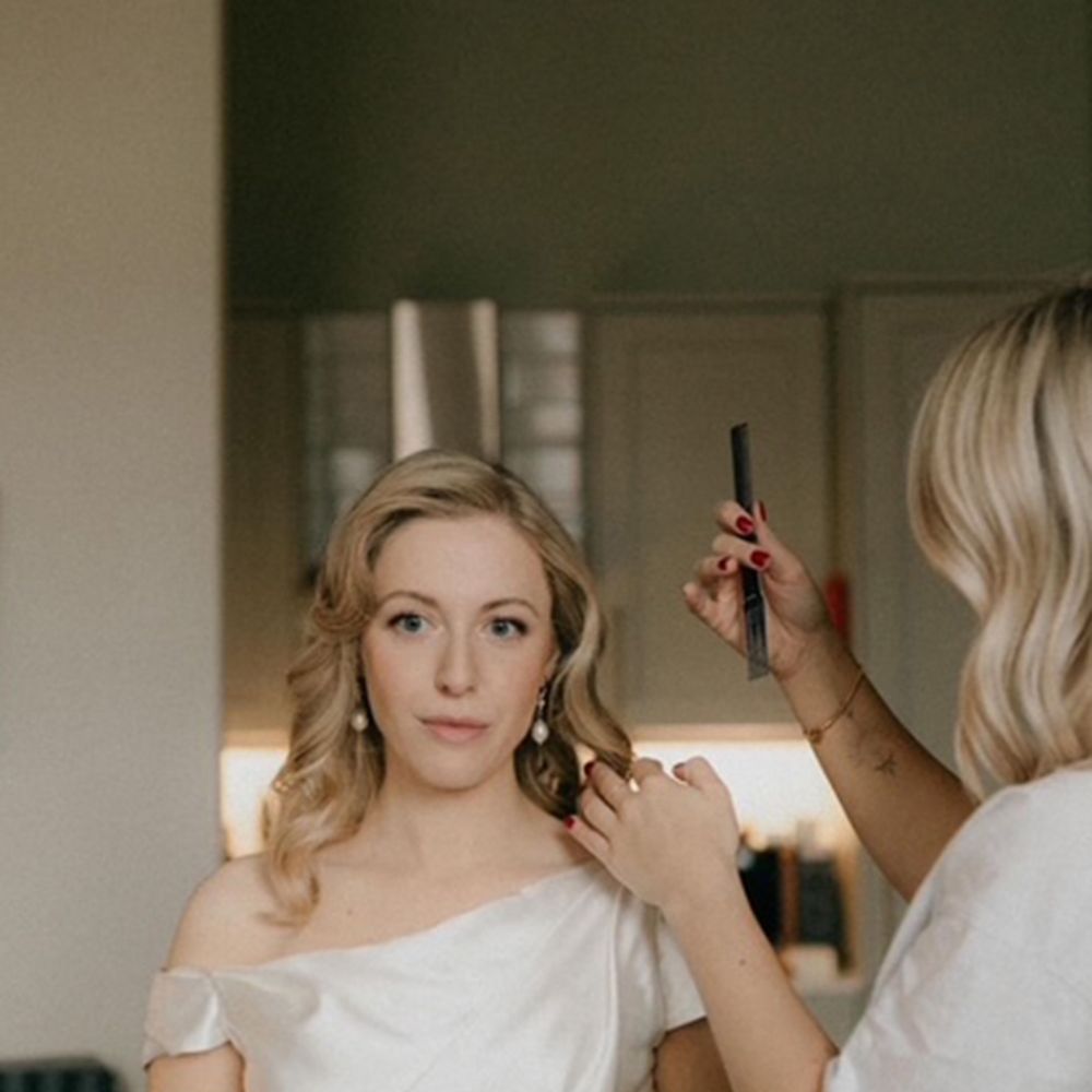 Bridal hairstylist prepping bride with comb