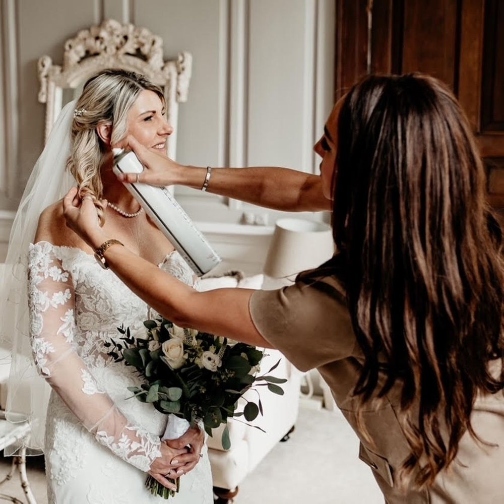 Wedding hairstylist styling bride’s hair during bridal preparation