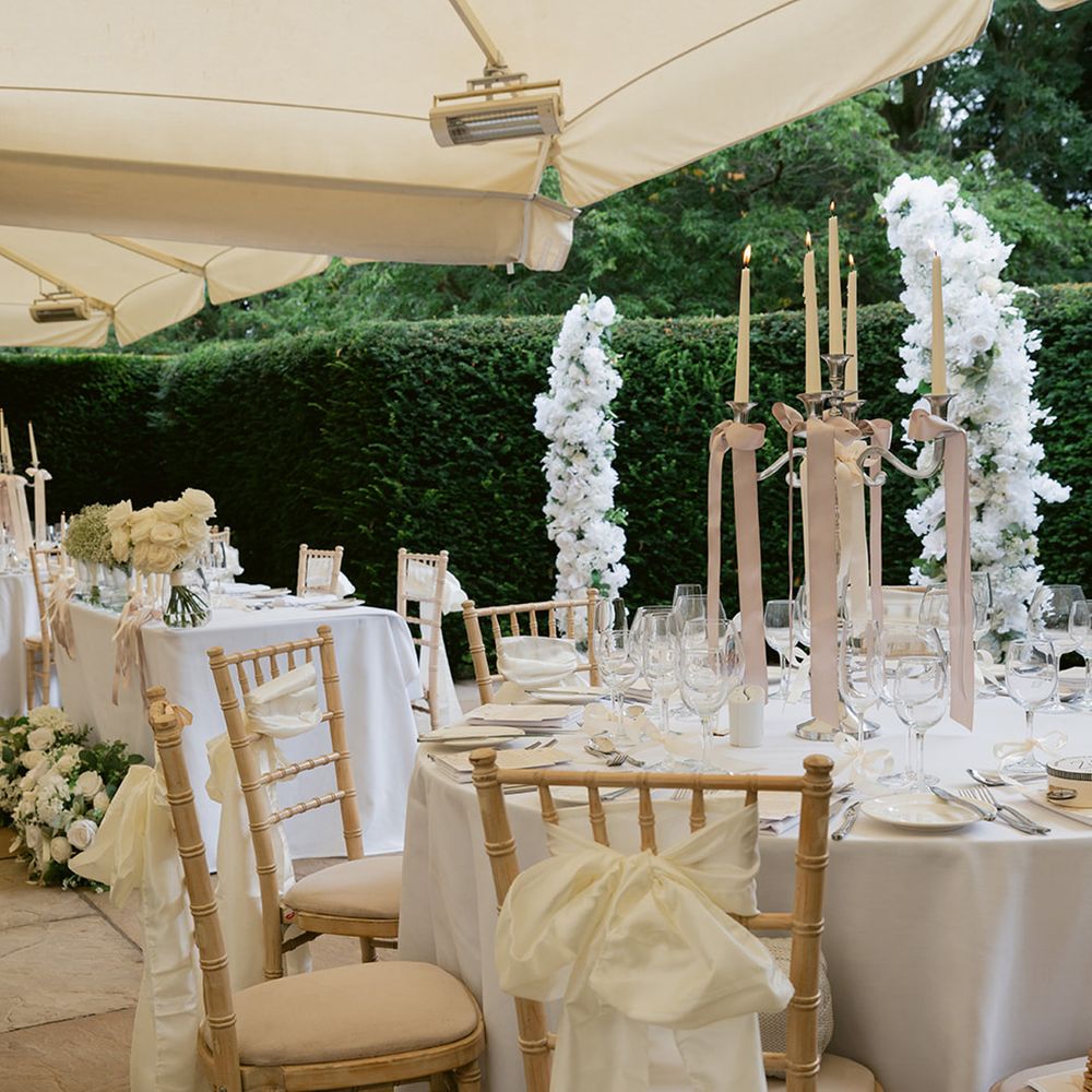 All white wedding tablescape under marquee