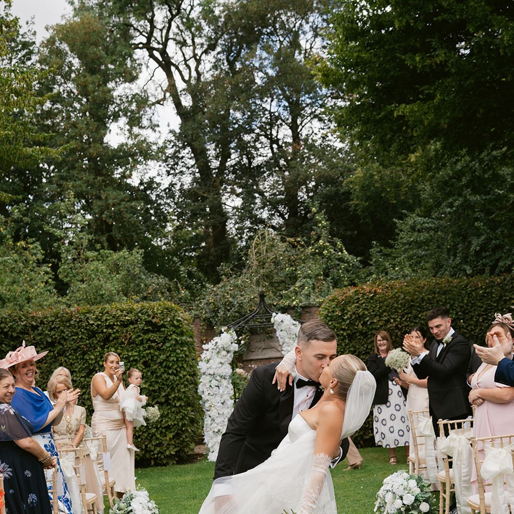 Couple kisses walking back down the aisle 