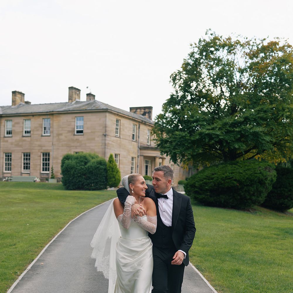 Saltmarshe Hall wedding venue with couple walking hand in hand together