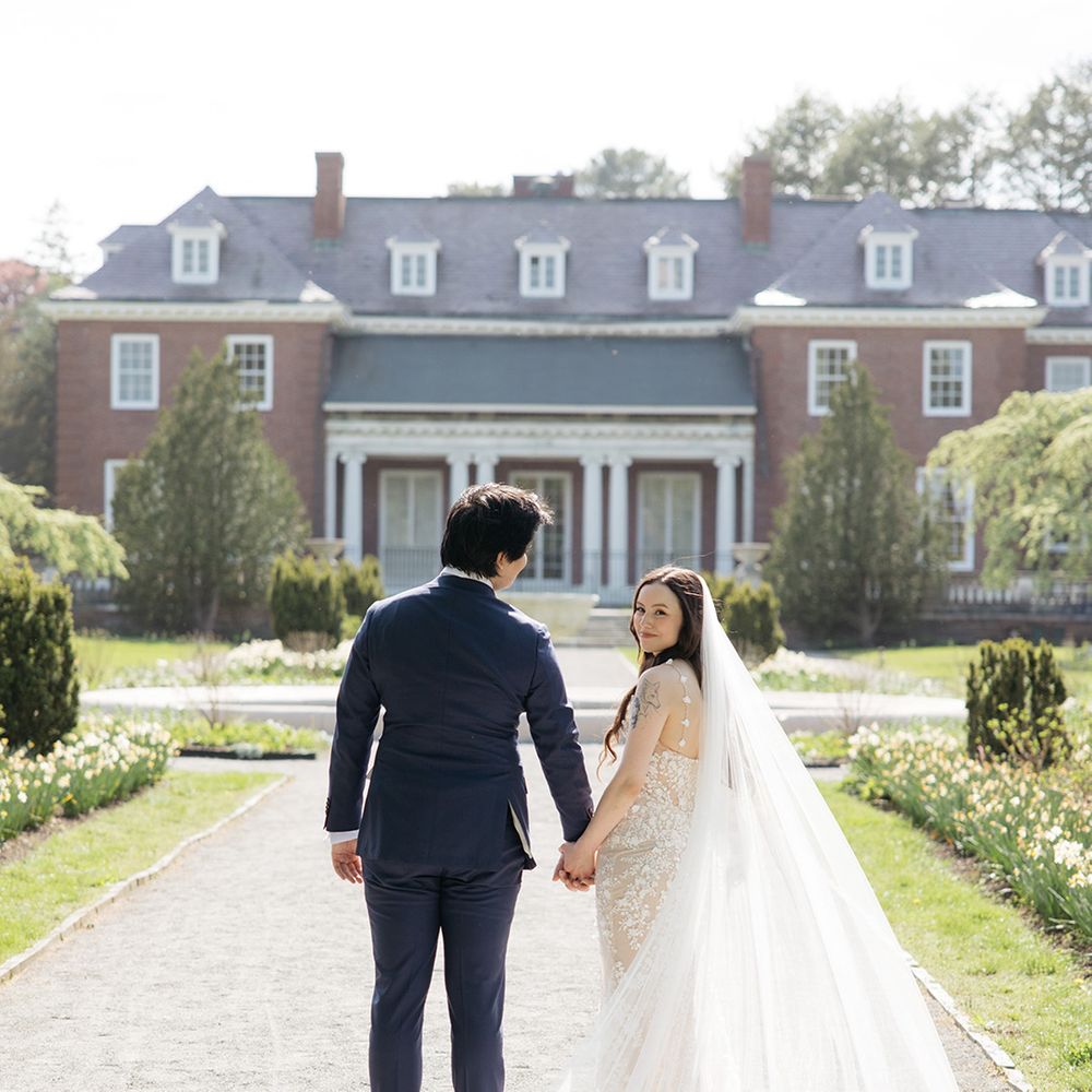 Bride and groom walking together at country house wedding 
