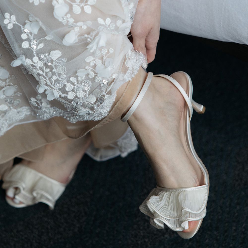 Bride puts on Loeffler Randall wedding shoes 