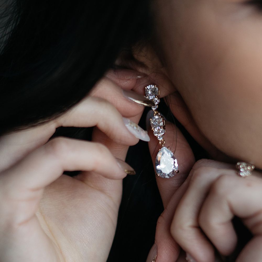 Bride wears diamond dangling earrings 