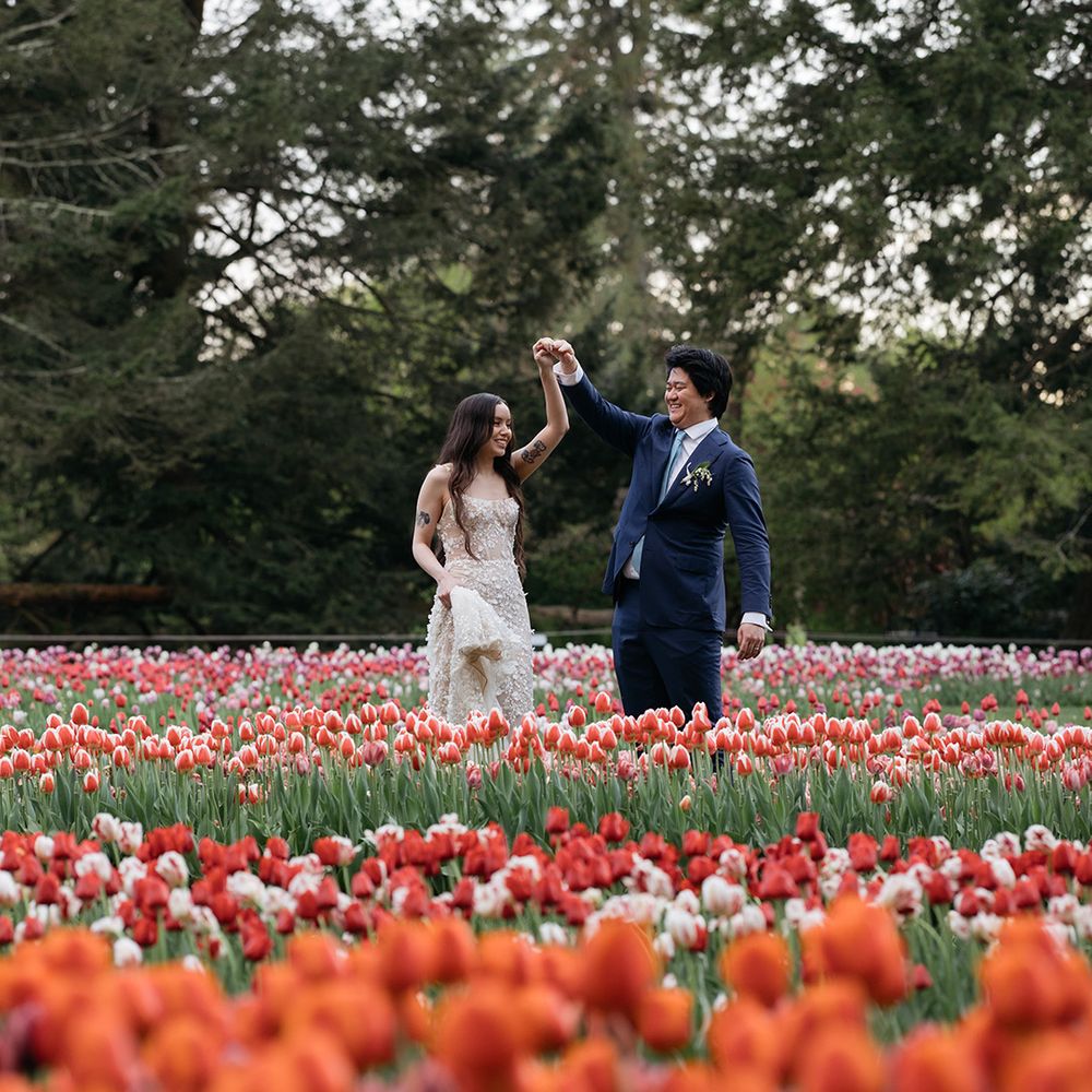 Couple dances together in tulip field at spring wedding