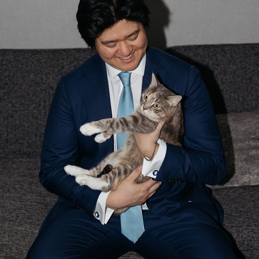 Groom in navy suit with pet cat 