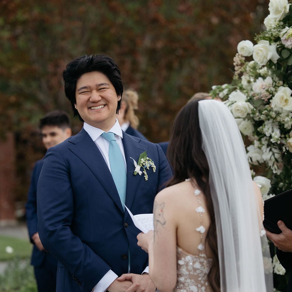 Groom smiling as he exchanges vows with bride 