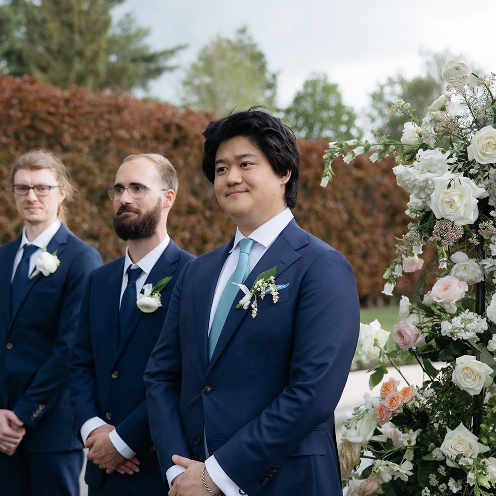 Groom stands as he sees bride walking down the aisle 
