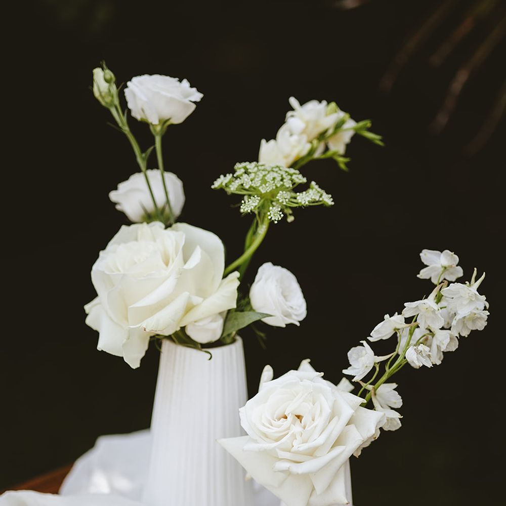White wedding flowers and roses in white vases