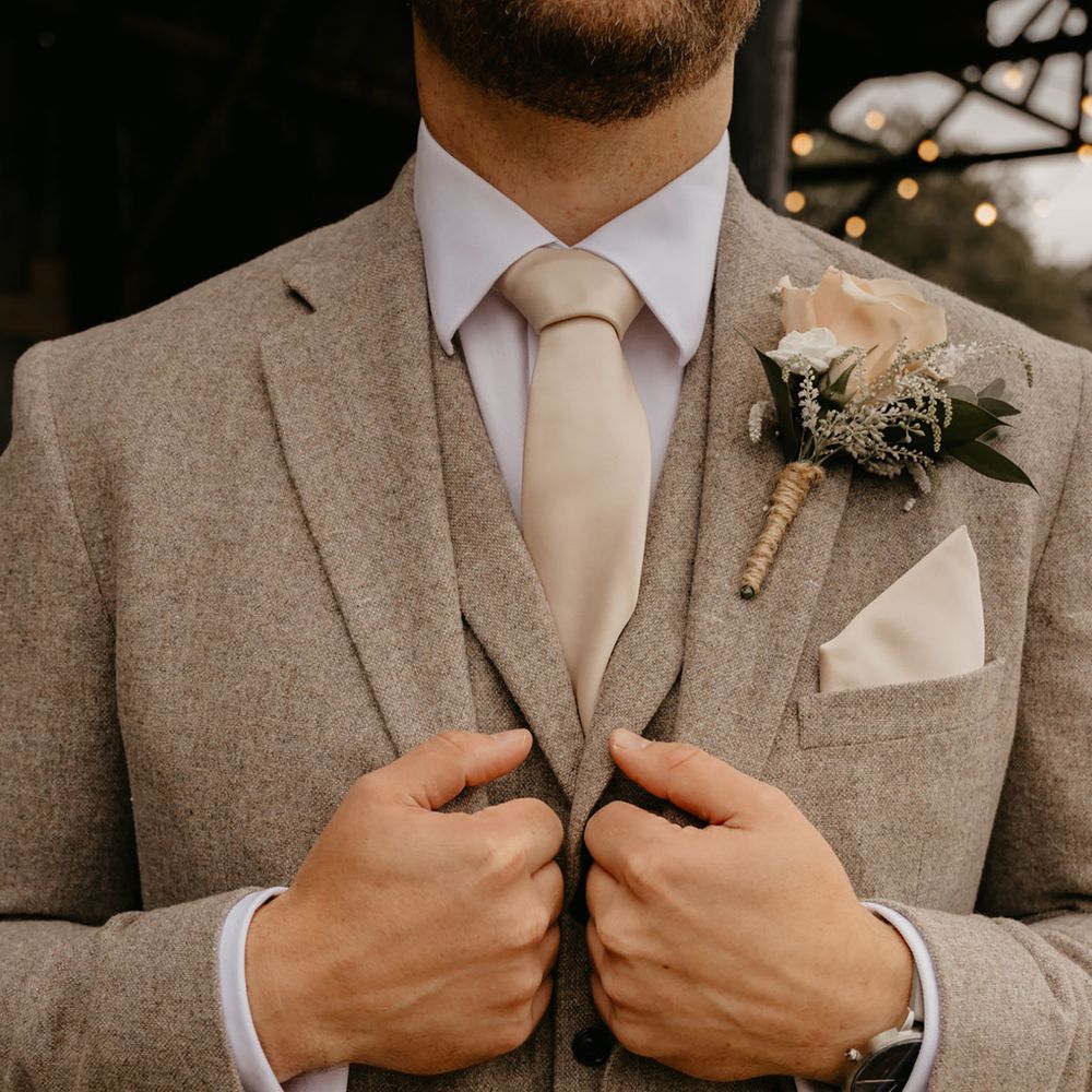 Groom wearing cream wedding tie with matching pocket square