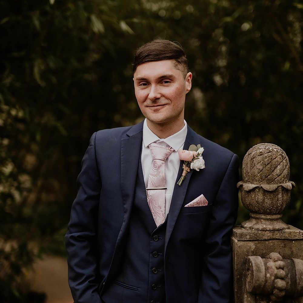 Groom wearing pale pink wedding tie with matching pocket square