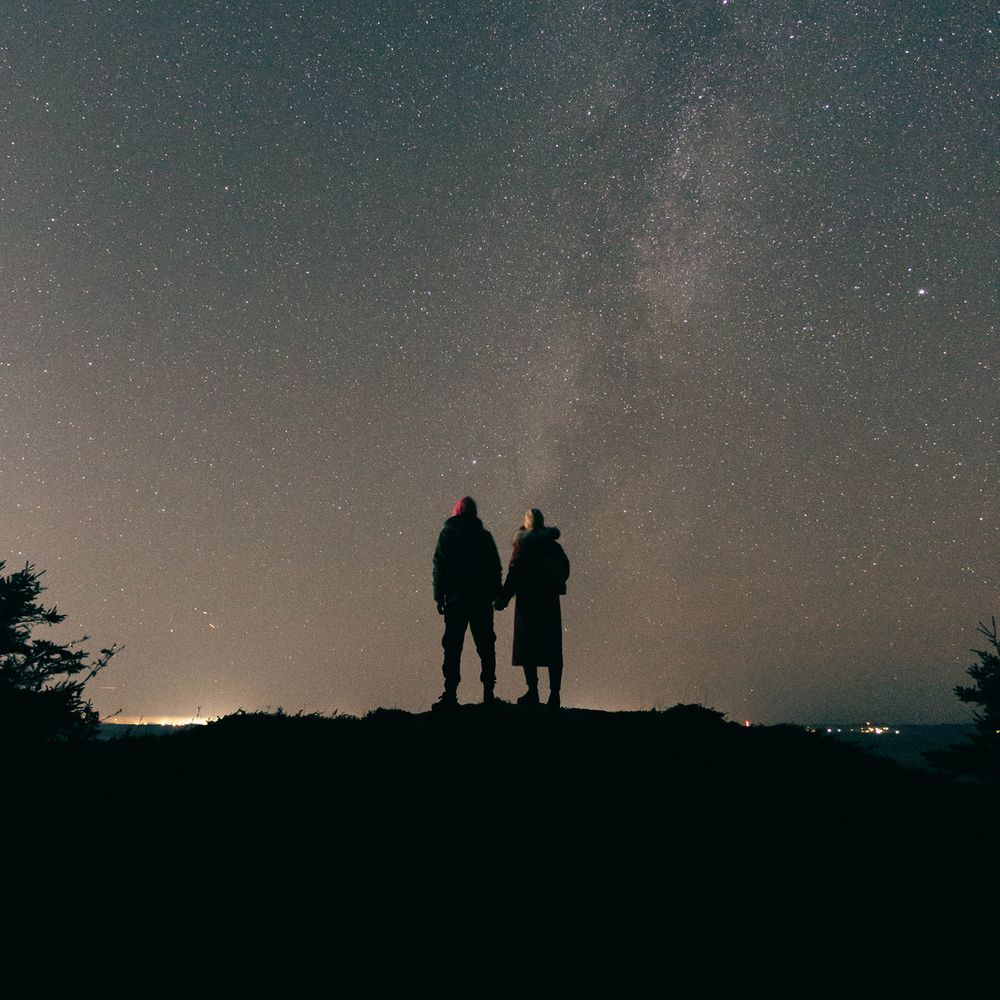 Couple holds hands as they stargaze together 