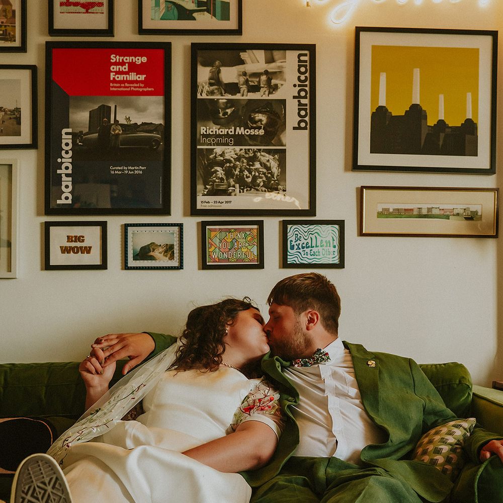 Bride and groom kiss on green vintage style sofa 