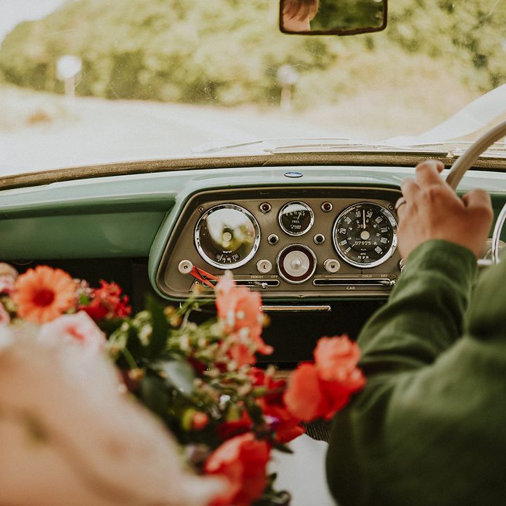Couple driving in vintage wedding car 