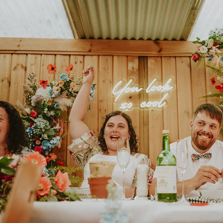 Couple laughing during wedding speeches sat on top table 