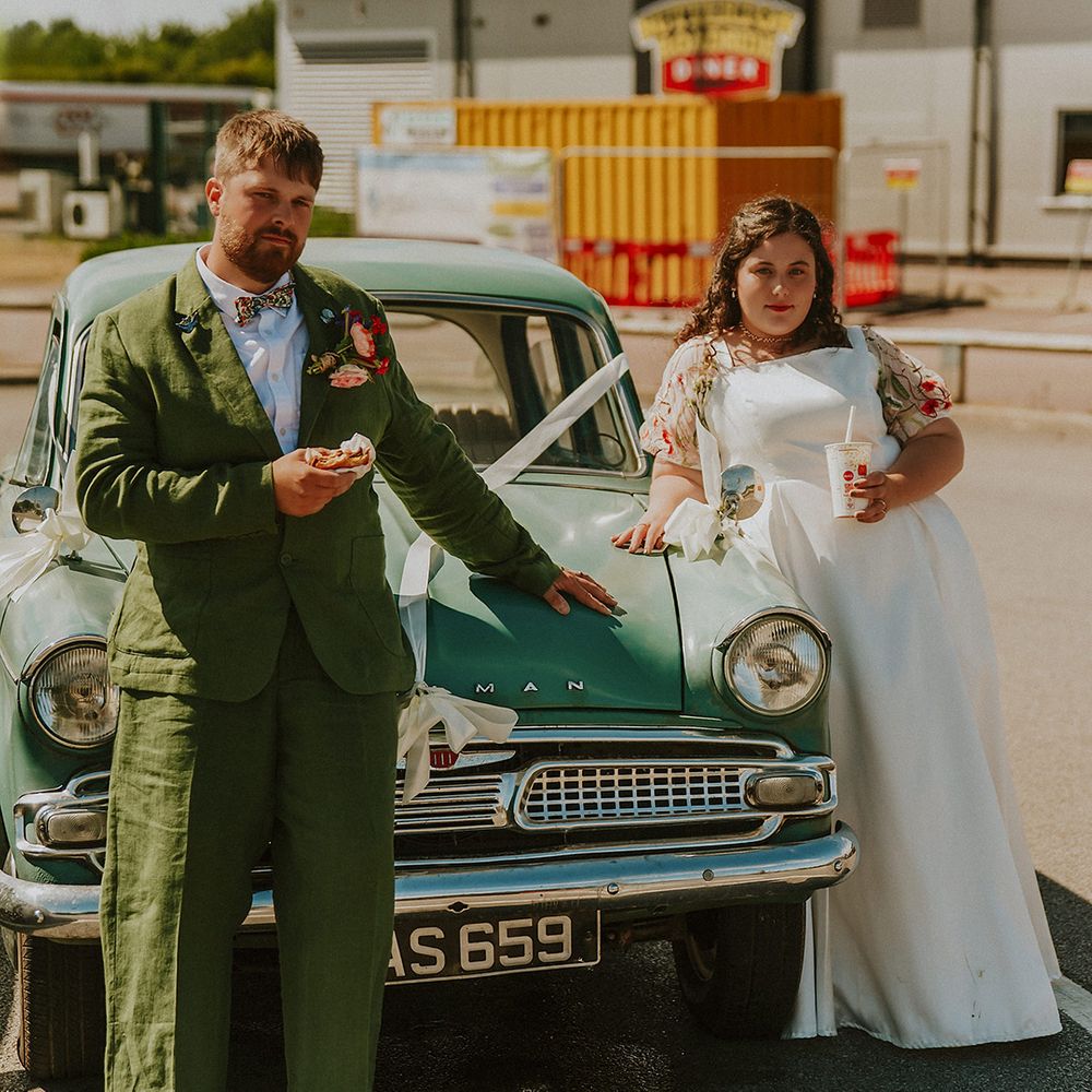 Bride and groom with their McDonald's food with vintage wedding car