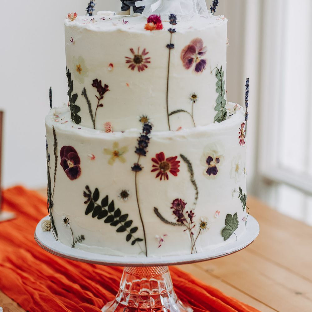 Botanical wedding cake with pressed wildflowers with rabbit cake topper