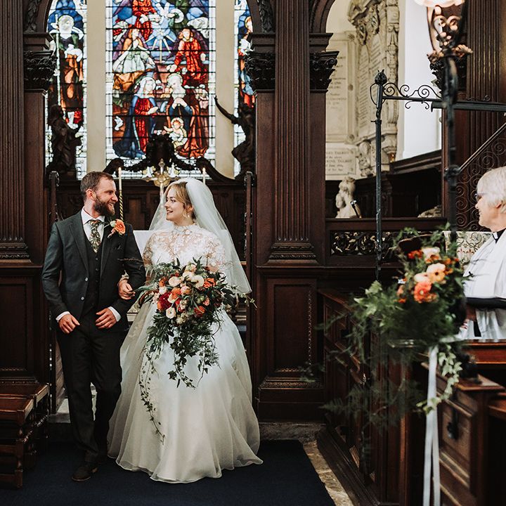 Bride and groom walk back down the aisle as a married couple at church wedding