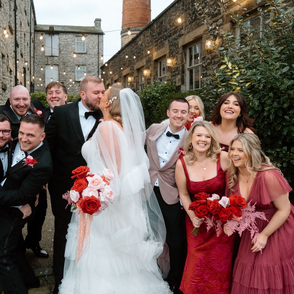 bride and groom share kiss with bridal party
